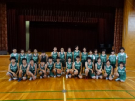 体育館でバスケットボールのユニフォーム姿の児童たちが整列している写真