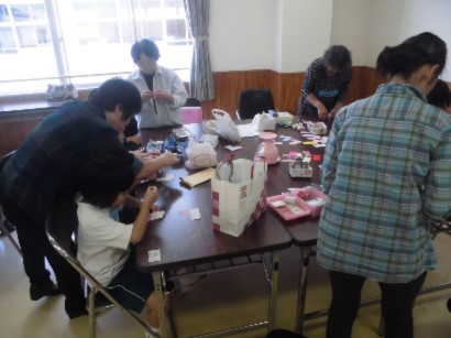 教室の机の上で児童たちが地域の講師に教えてもらいながら工作している写真