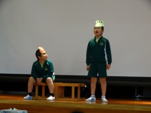 体操服姿でお面を頭に付けた2人の児童がステージ上で演技をしている写真