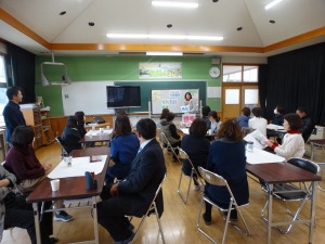 教室で複数の男女が向かい合って椅子に座り話を聞いている写真