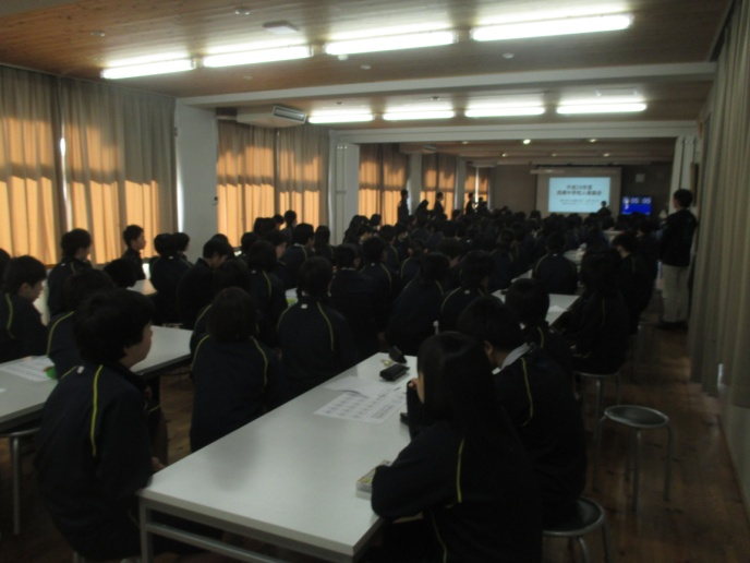 多くの生徒が机に向かって座り、前方に映し出されたスクリーンを見ている写真