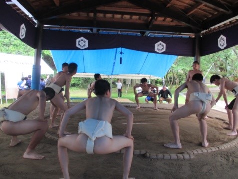 土俵でまわし姿の生徒が四股を踏んでいる写真