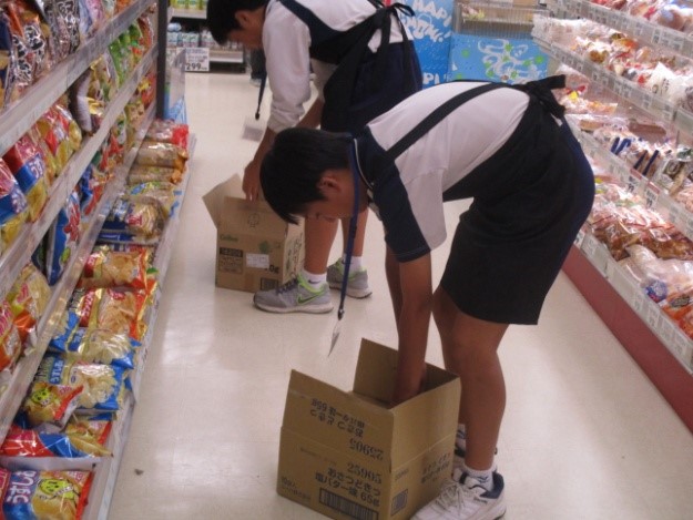 男子生徒2人が屈みながら品出し作業を行っている写真