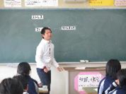 教室で先生が黒板の前に立ち生徒にストレスについての授業をしている写真