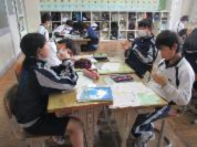 教室で生徒たちが机を囲み話し合いながら授業をしている写真