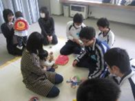 教室でお母さんと赤ちゃんを前に授業を受けている生徒の写真