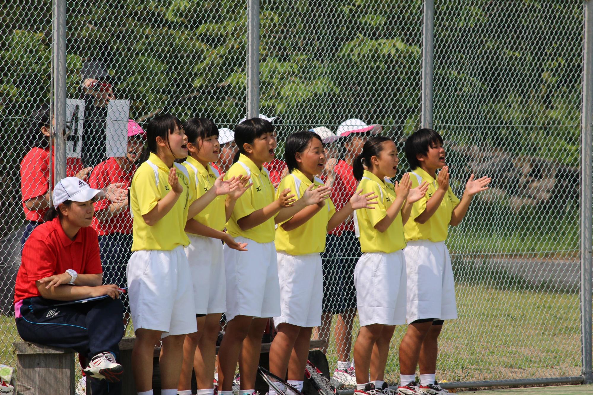 ユニホーム姿の女子生徒たちが応援している写真