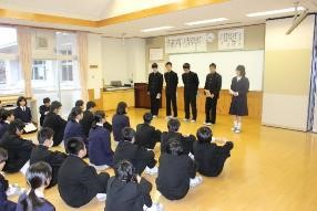 生徒たちが前に並び発表し、他の生徒が座って聞いている写真