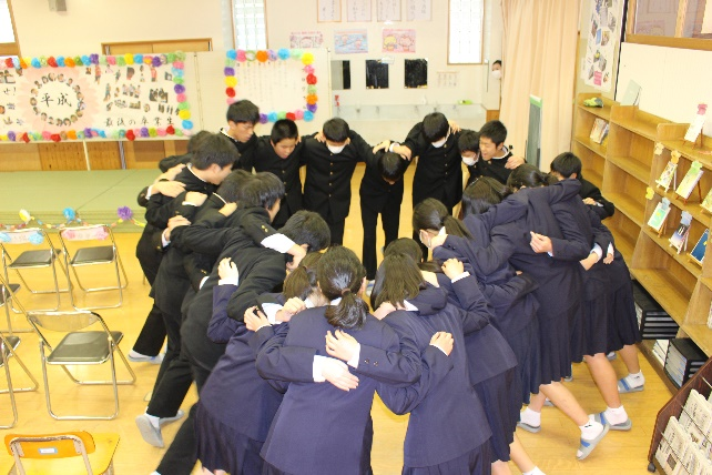 生徒たちが教室で円陣を組んで士気を高めている写真