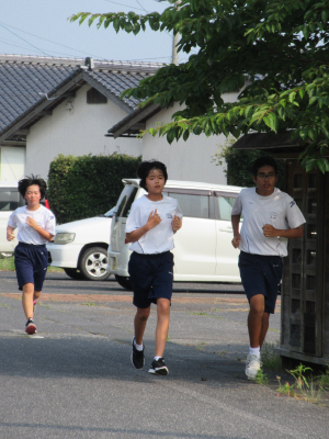 体育着姿の生徒たちが道路を走っている写真