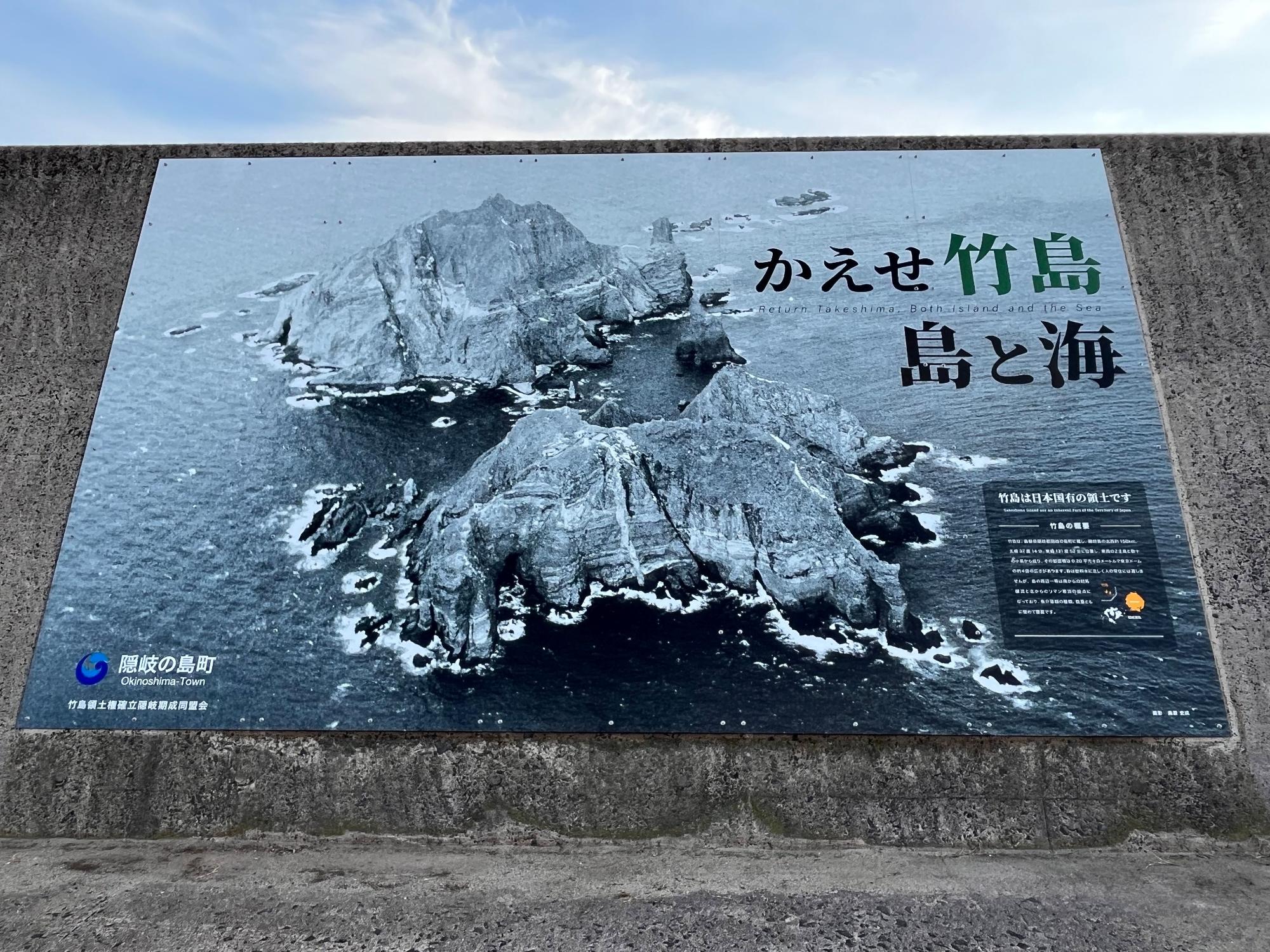 竹島の写真と解説があり、「かえせ竹島 島と海」と大きく書かれている竹島パネルの写真