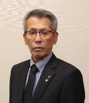 スーツ姿で眼鏡をかけた男性が真正面を向いている証明写真