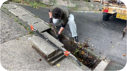 側溝掃除する男性職員の写真