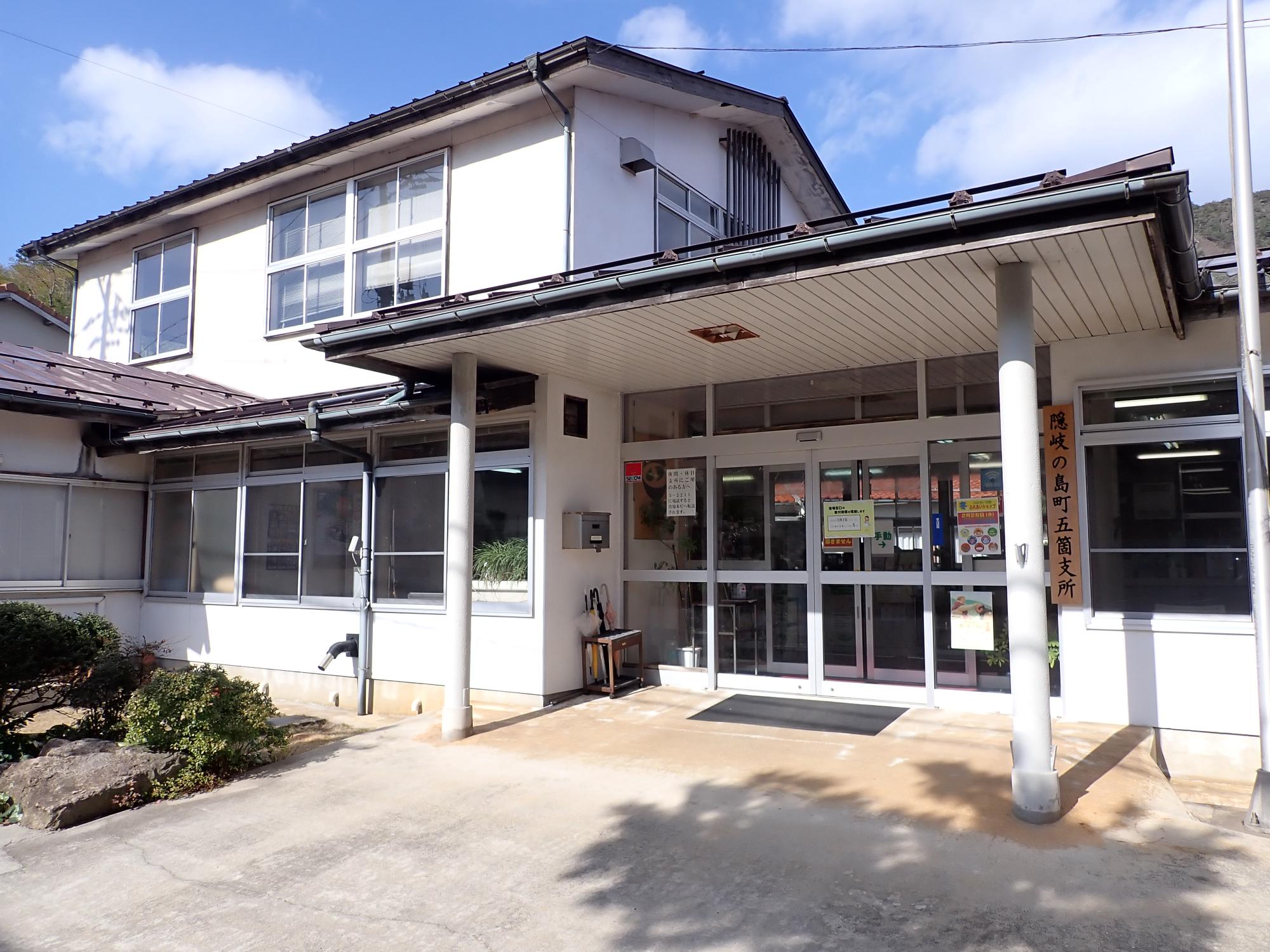 植木がされている外構の奥に白い建物がある写真