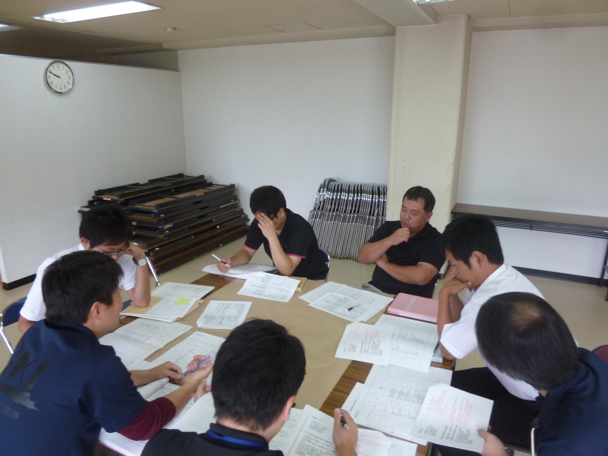 男性7人のグループで話し合いをしている職員たちの写真