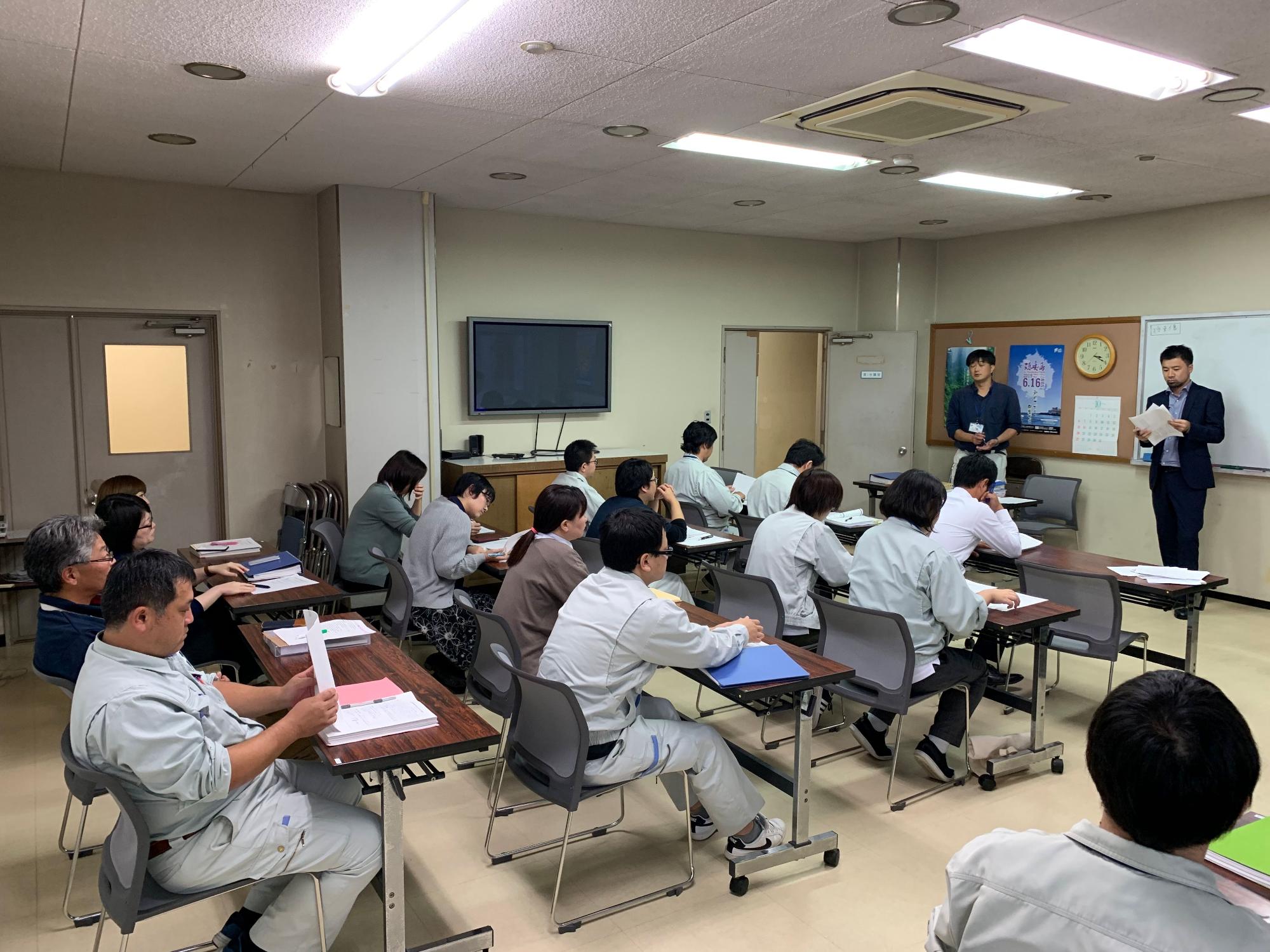 会議を進行している職員と話を聞いている職員たちの写真