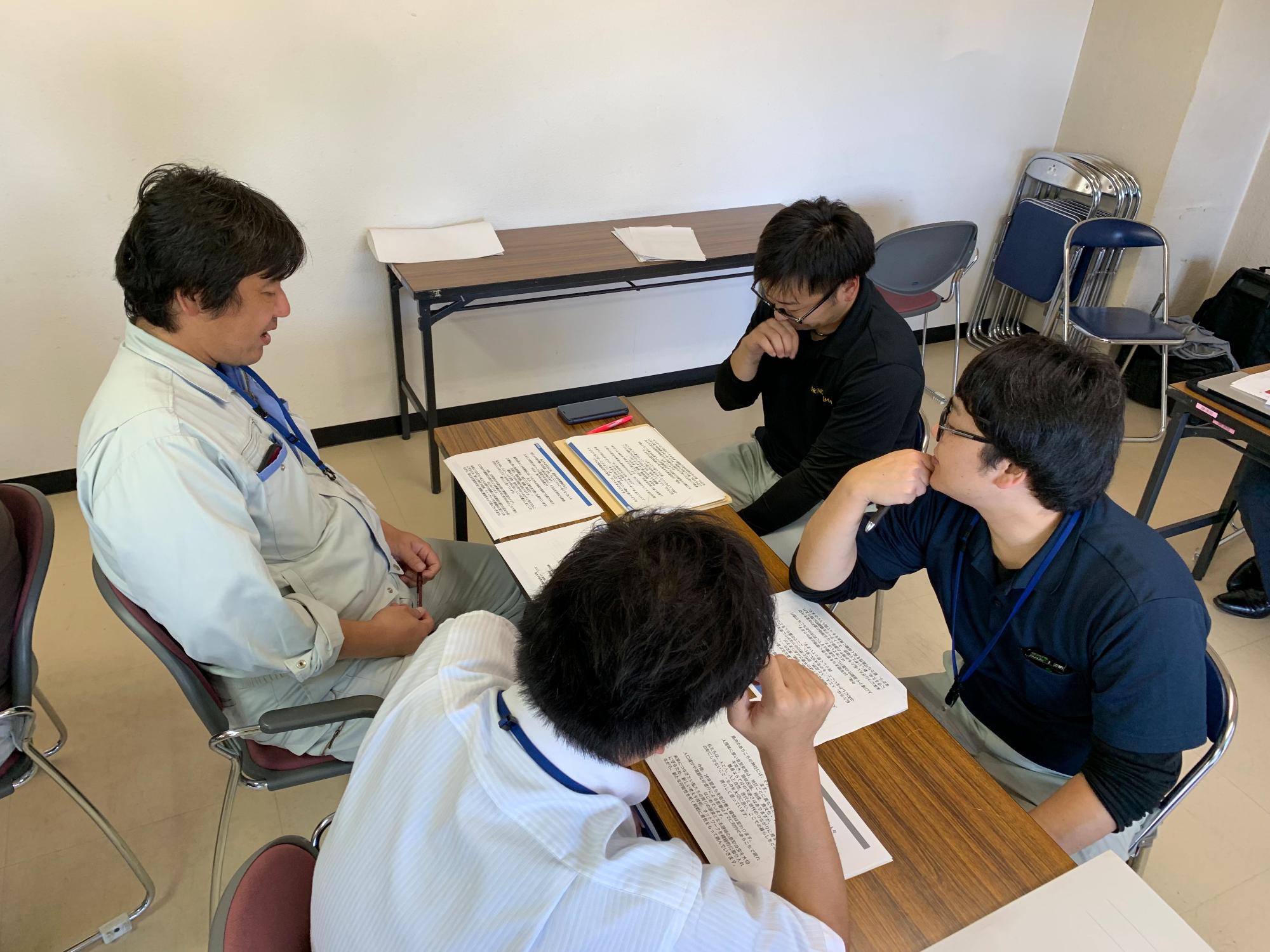 男性4人のグループで話し合っている職員たちの写真