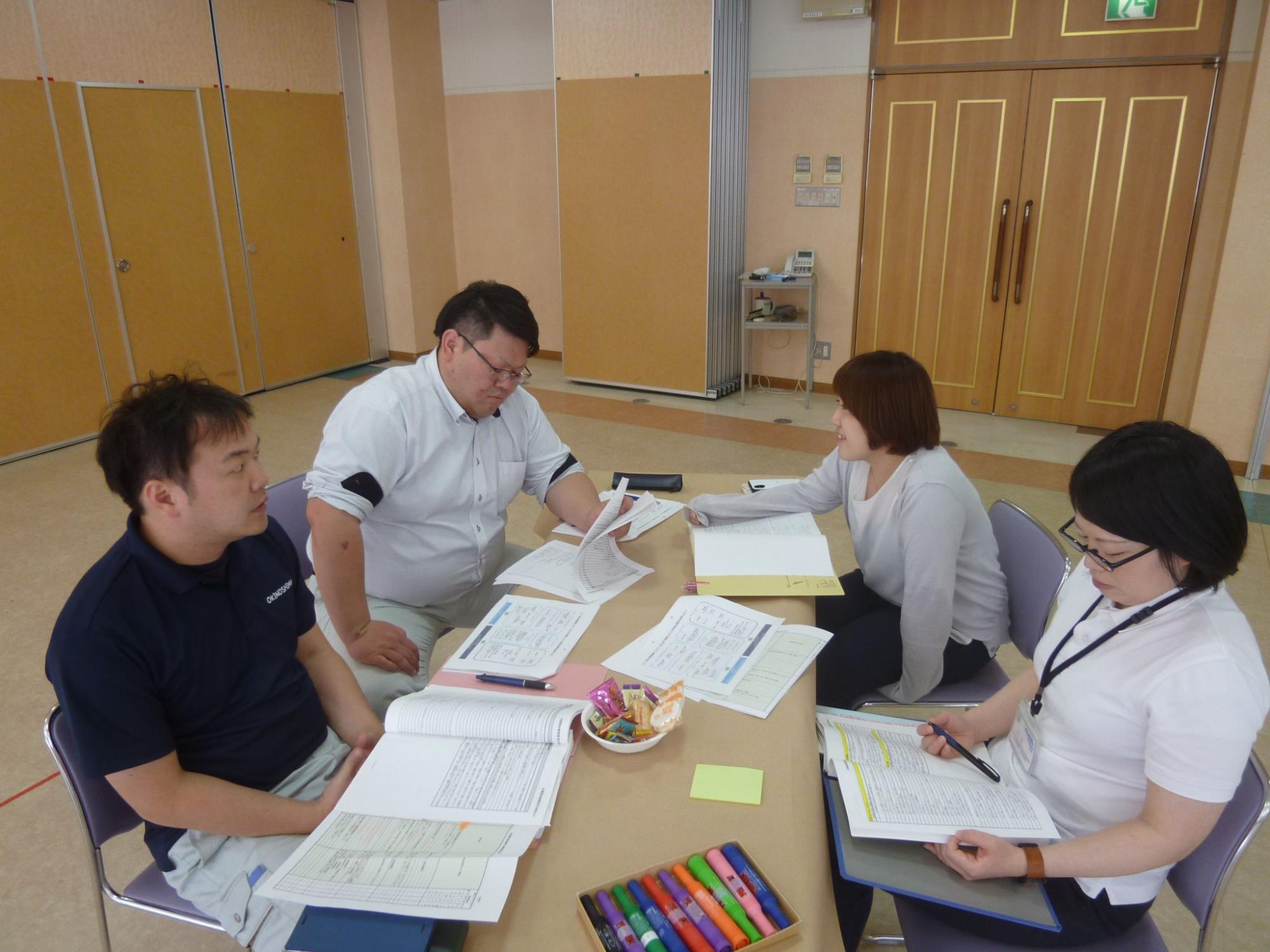 書類を見ながら話し合いをしている職員たちの写真