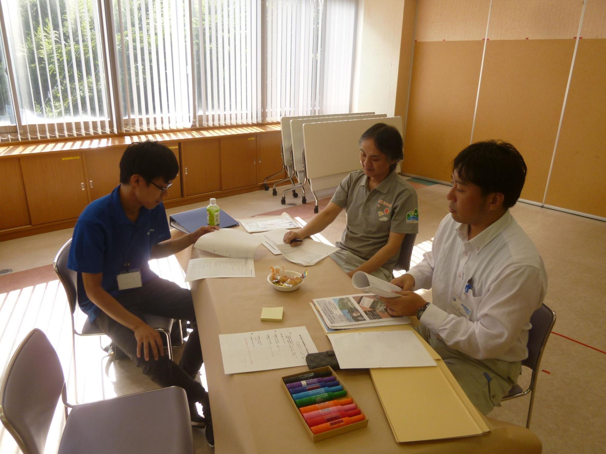 3人グループで話し合いをしている職員たちの写真