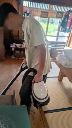 掃除機を持って掃除している様子の写真