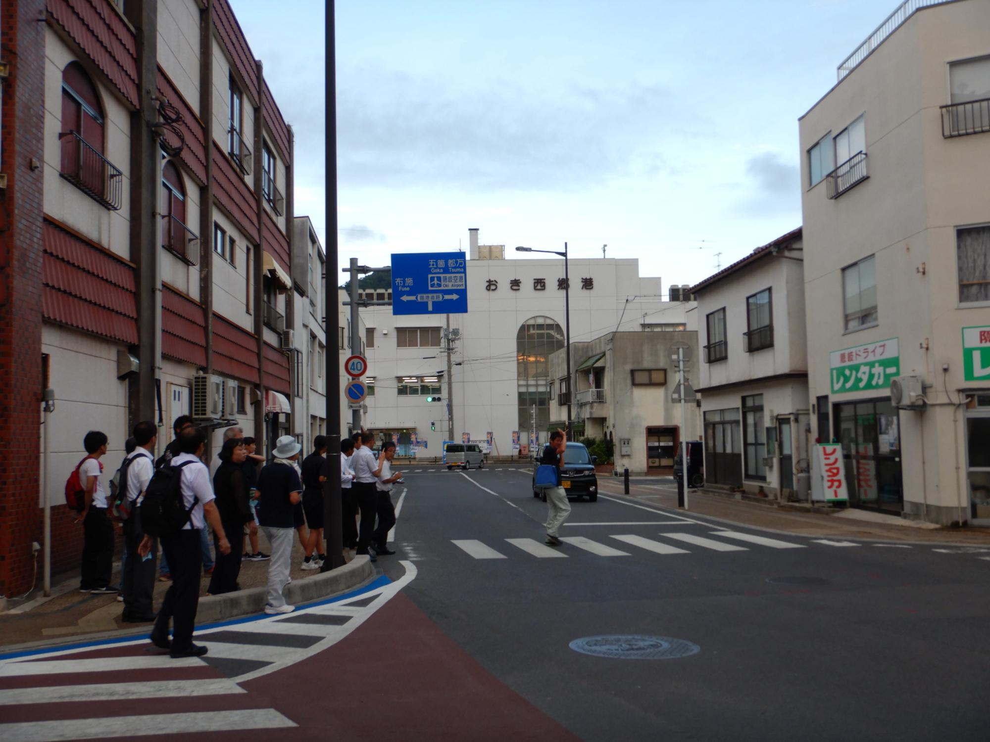 横断歩道を渡る男性を見ている複数人の写真