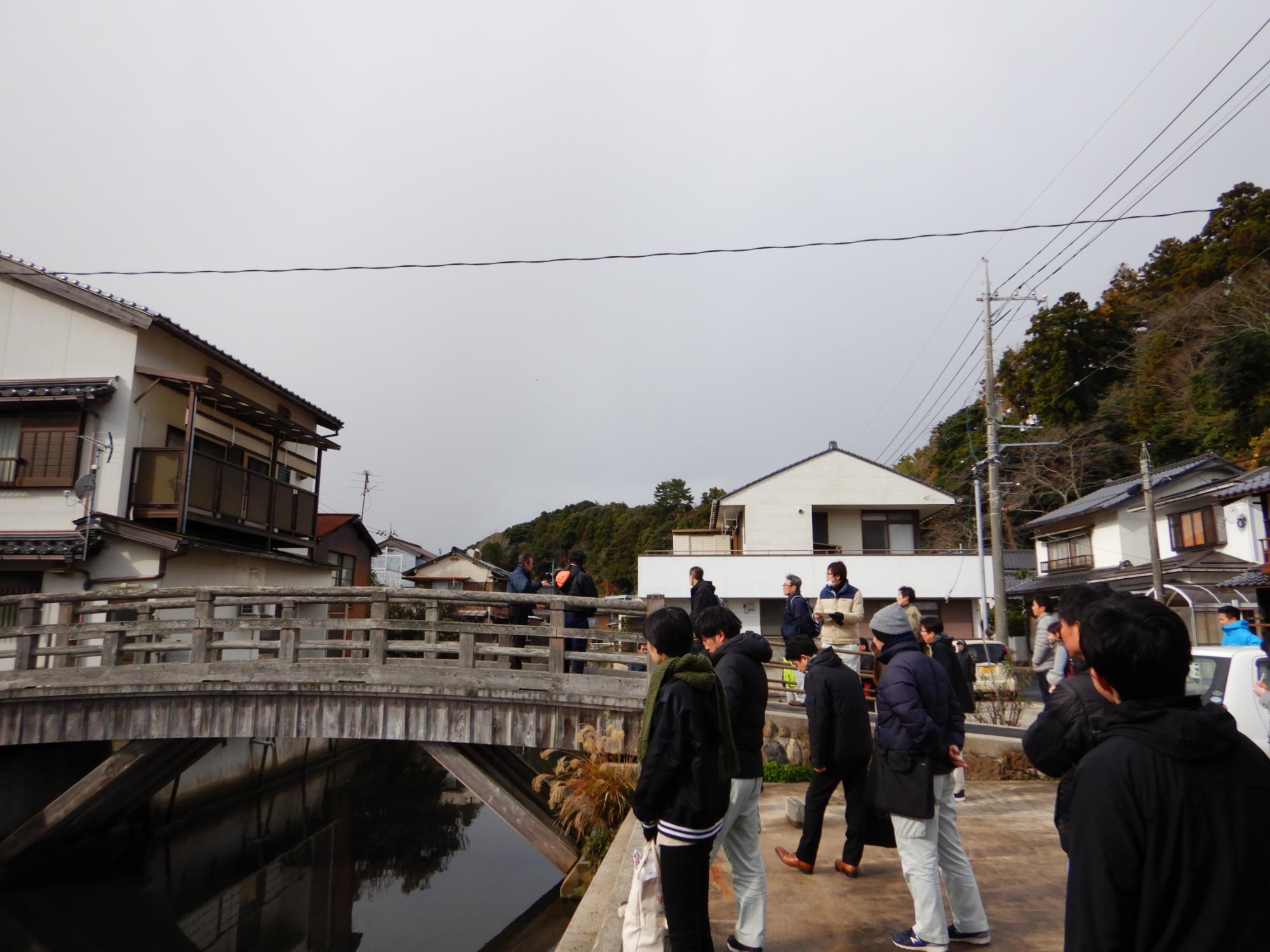 橋のかかった水路を見ている人たちの写真