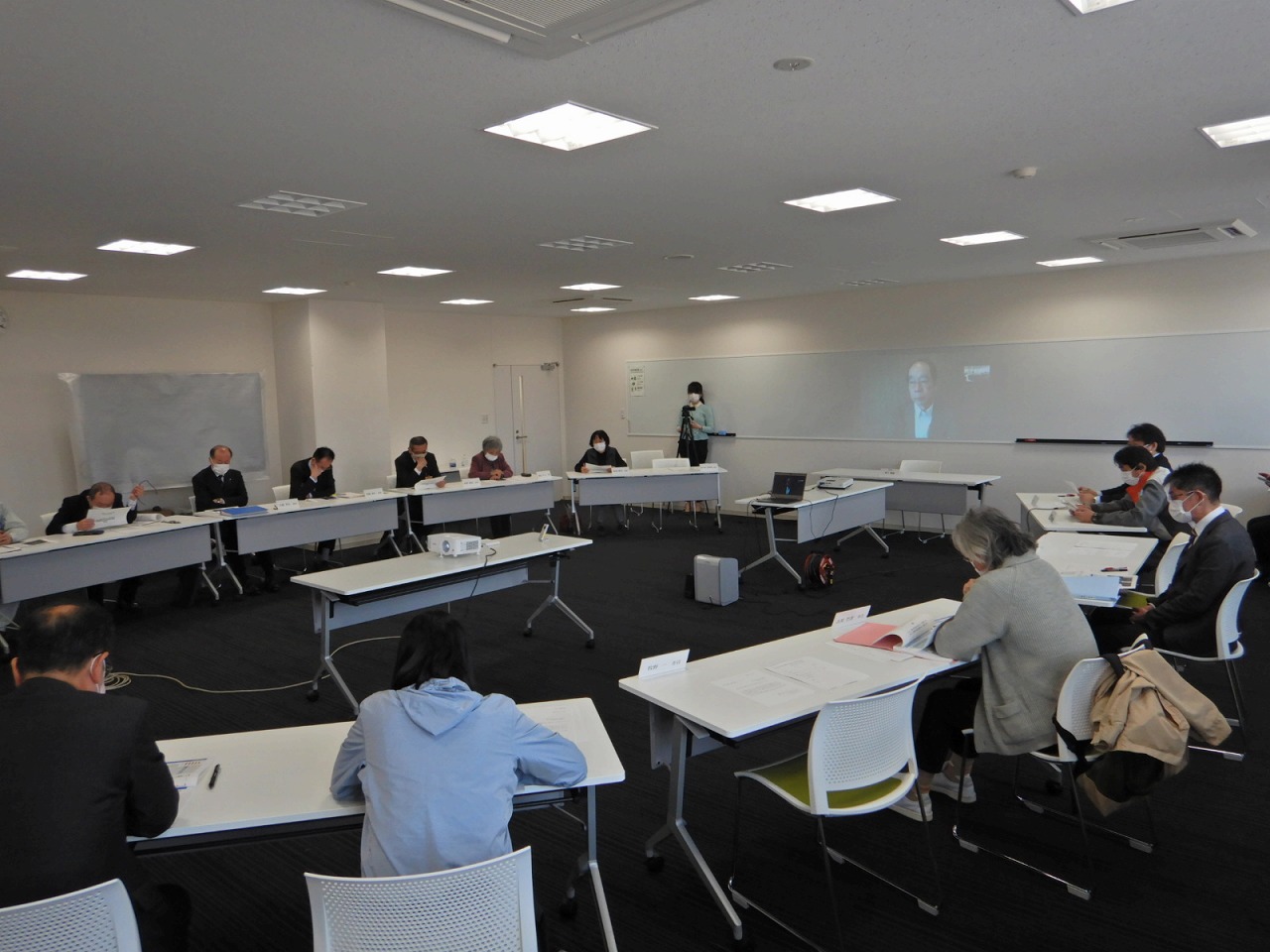 会議室の席に座っている人たちの写真