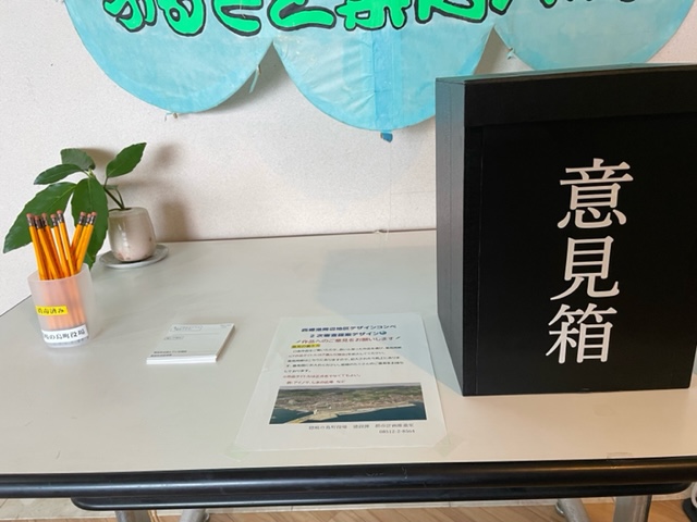机に置かれた「意見箱」と書かれた黒い箱の写真