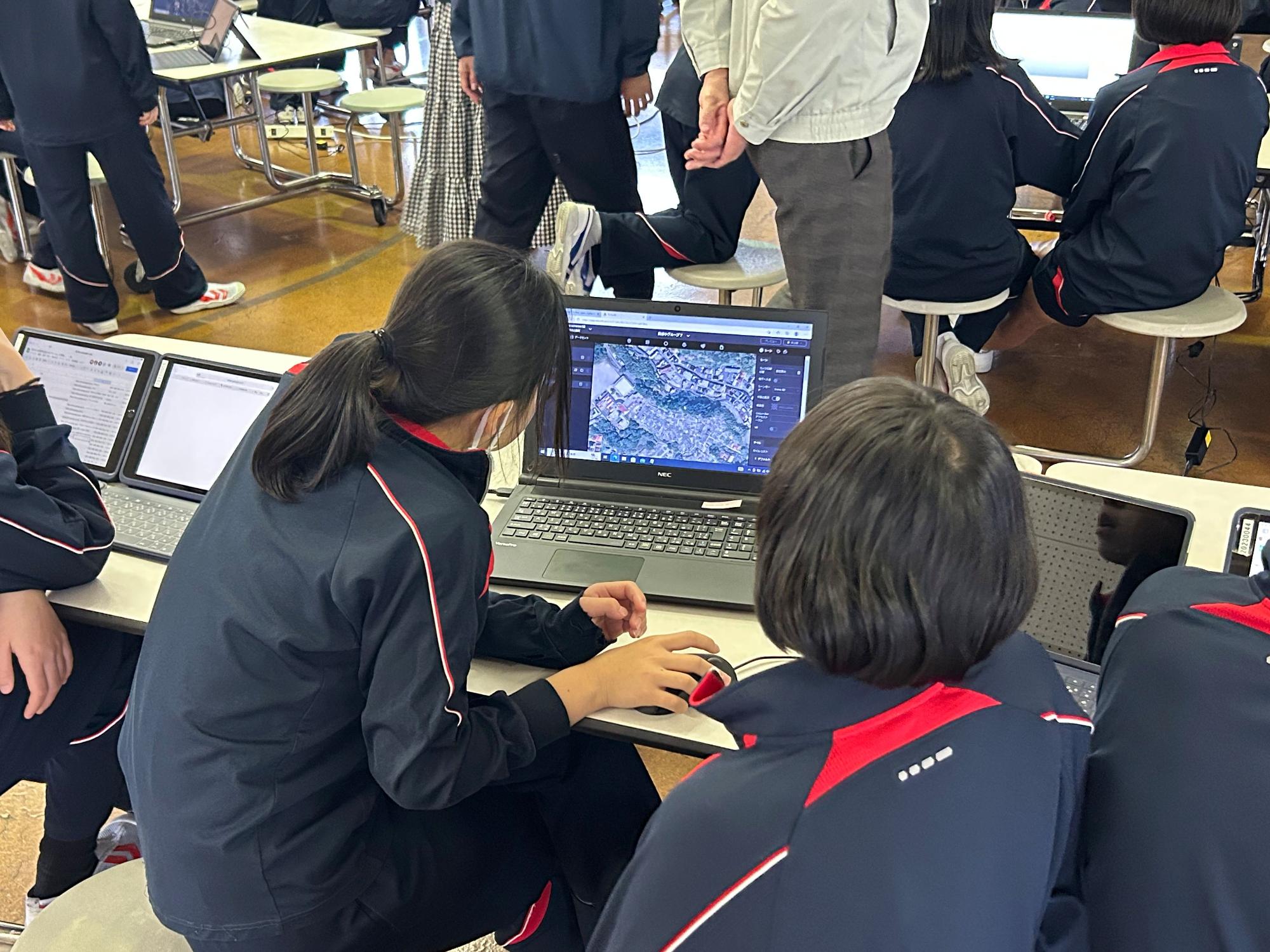 ジャージを着た生徒たちがパソコンを操作している写真