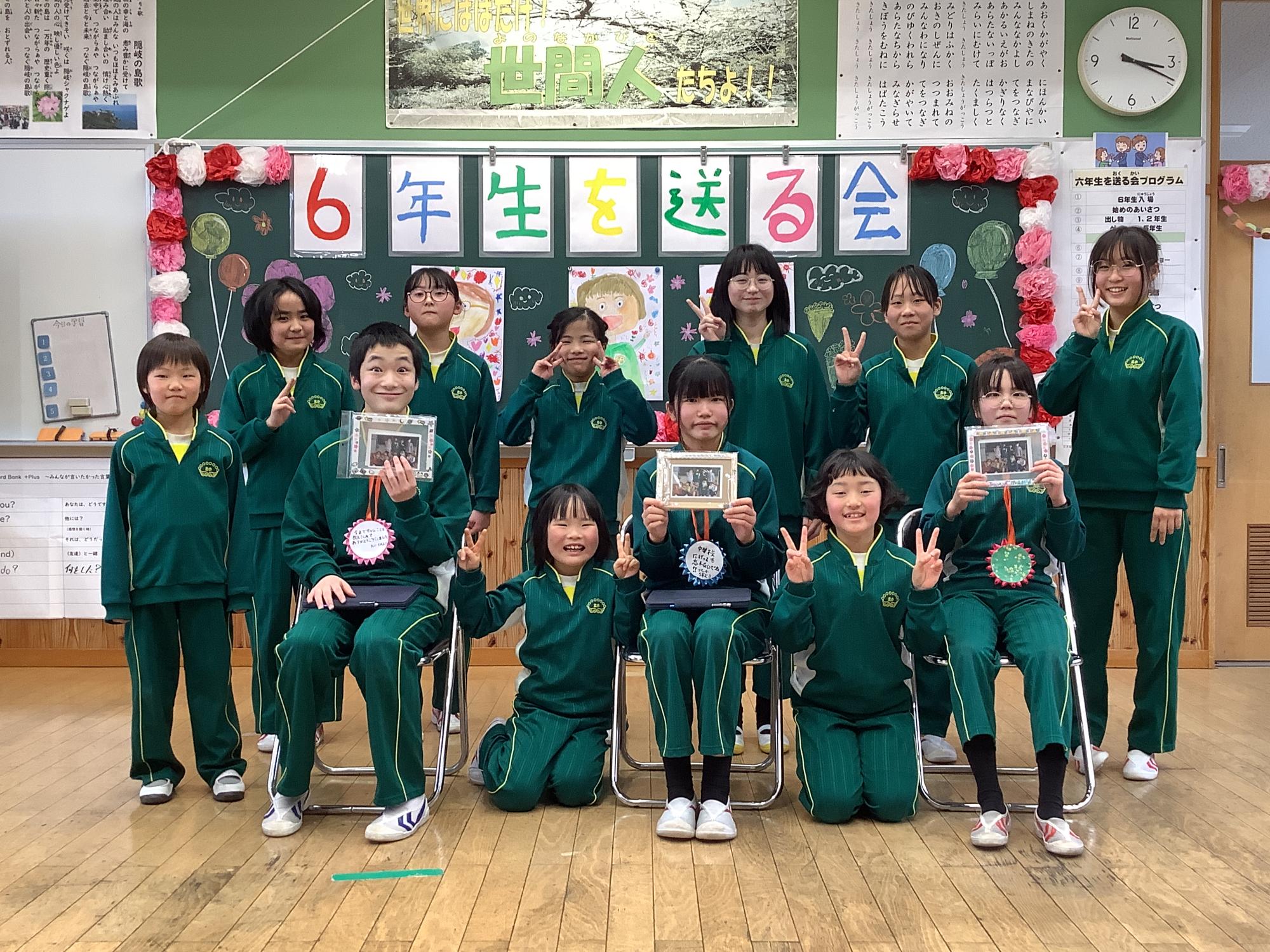 6年生を送る会にて北小学校児童12名が一緒になってピースしている写真