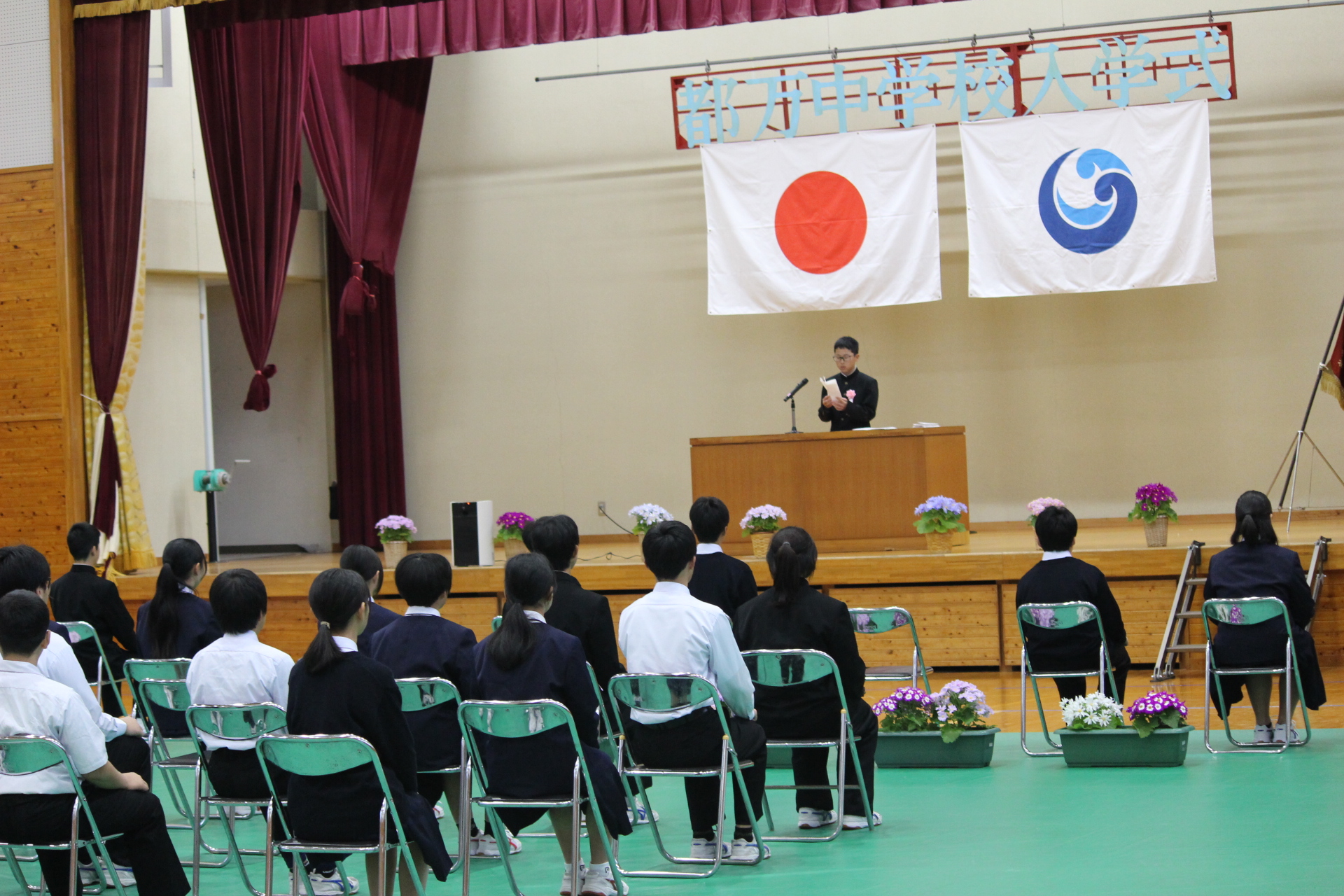 入学式にて代表者挨拶をステージ上でする児童の様子