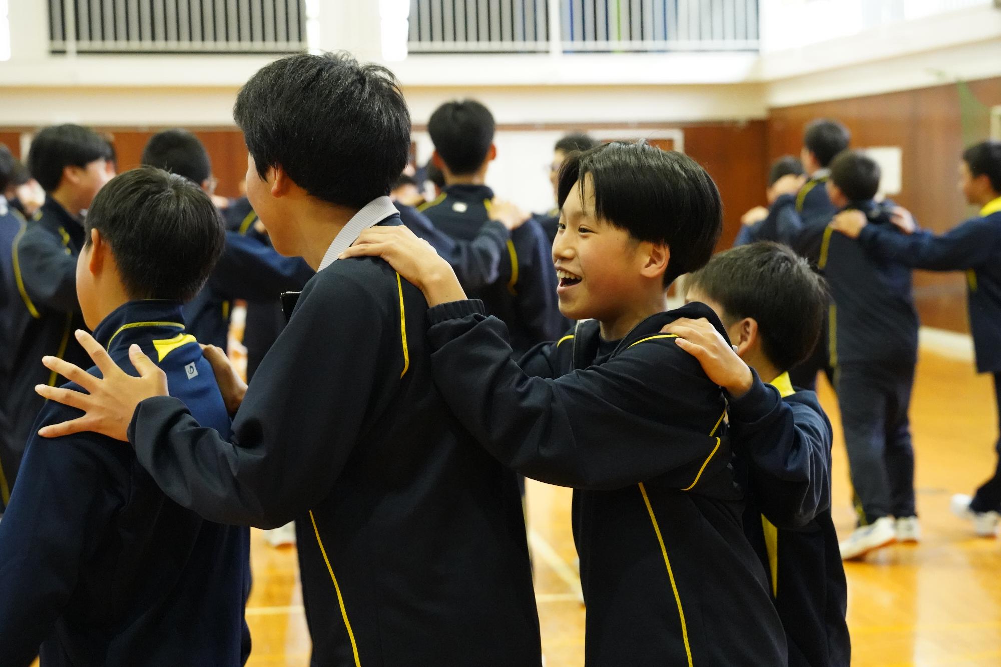肩をつかんで行進する生徒たち