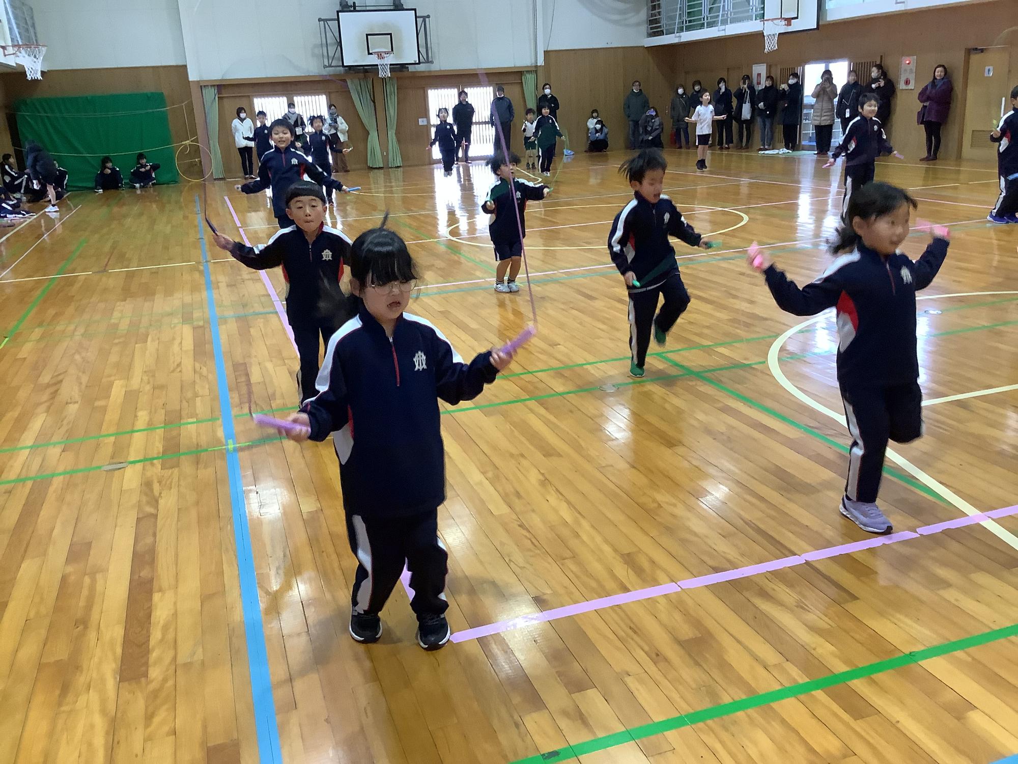 体育館で児童が縄跳びを回しながら跳ぶ様子