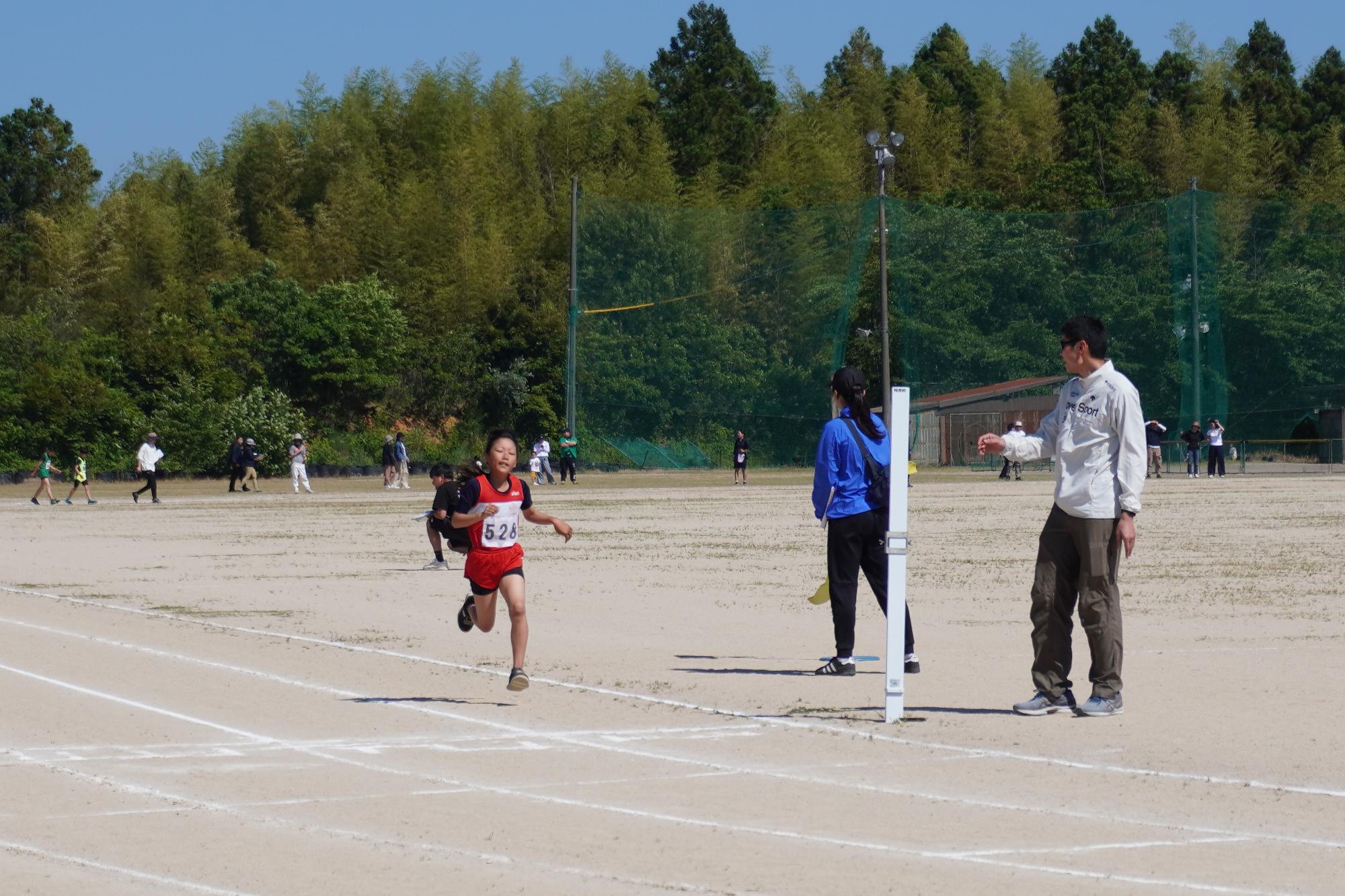 陸上大会にて、全力疾走する児童の様子
