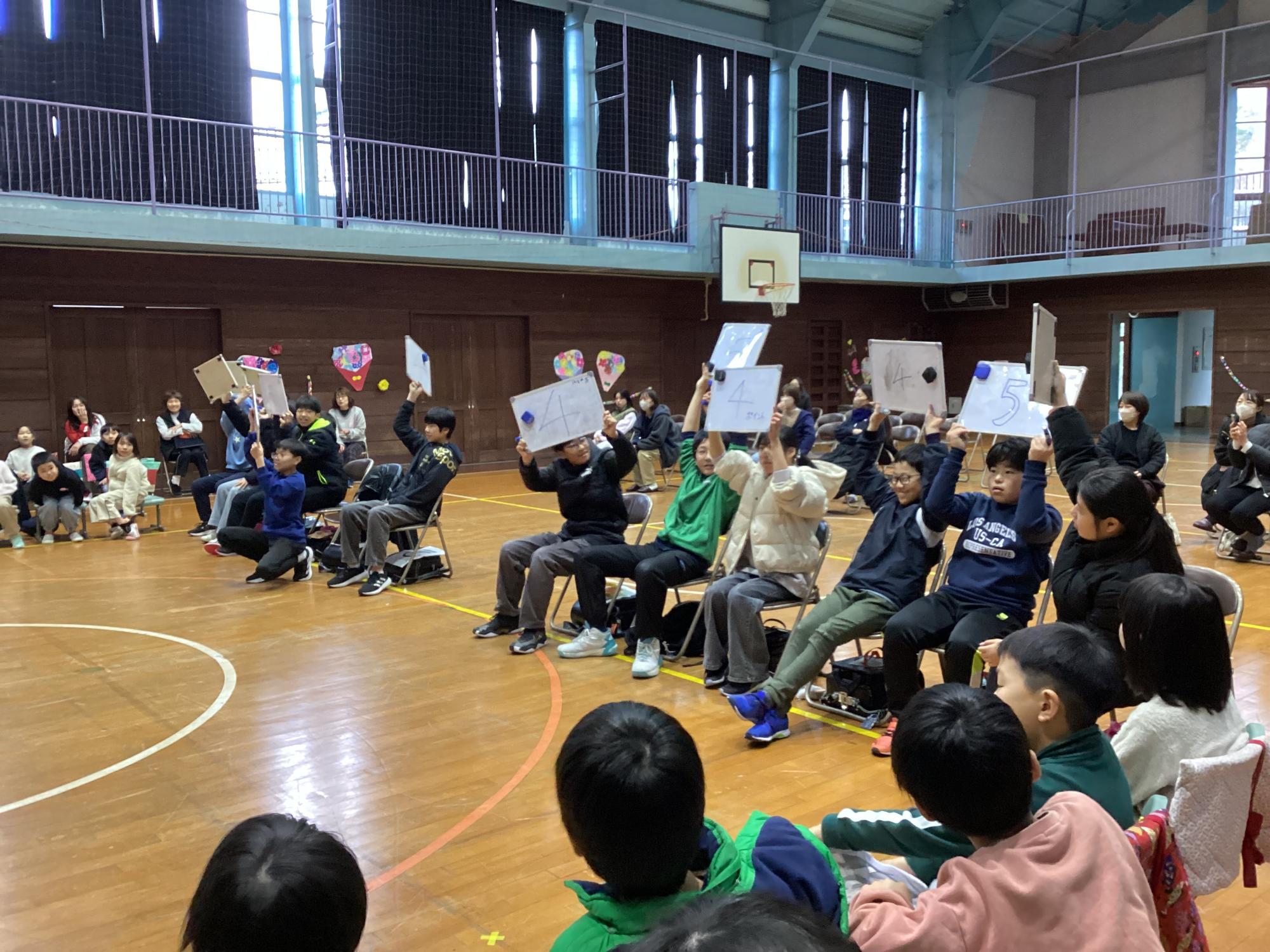 6年生を送る会にて都万小学校6年生児童と出し物を楽しむ在校生の児童たち
