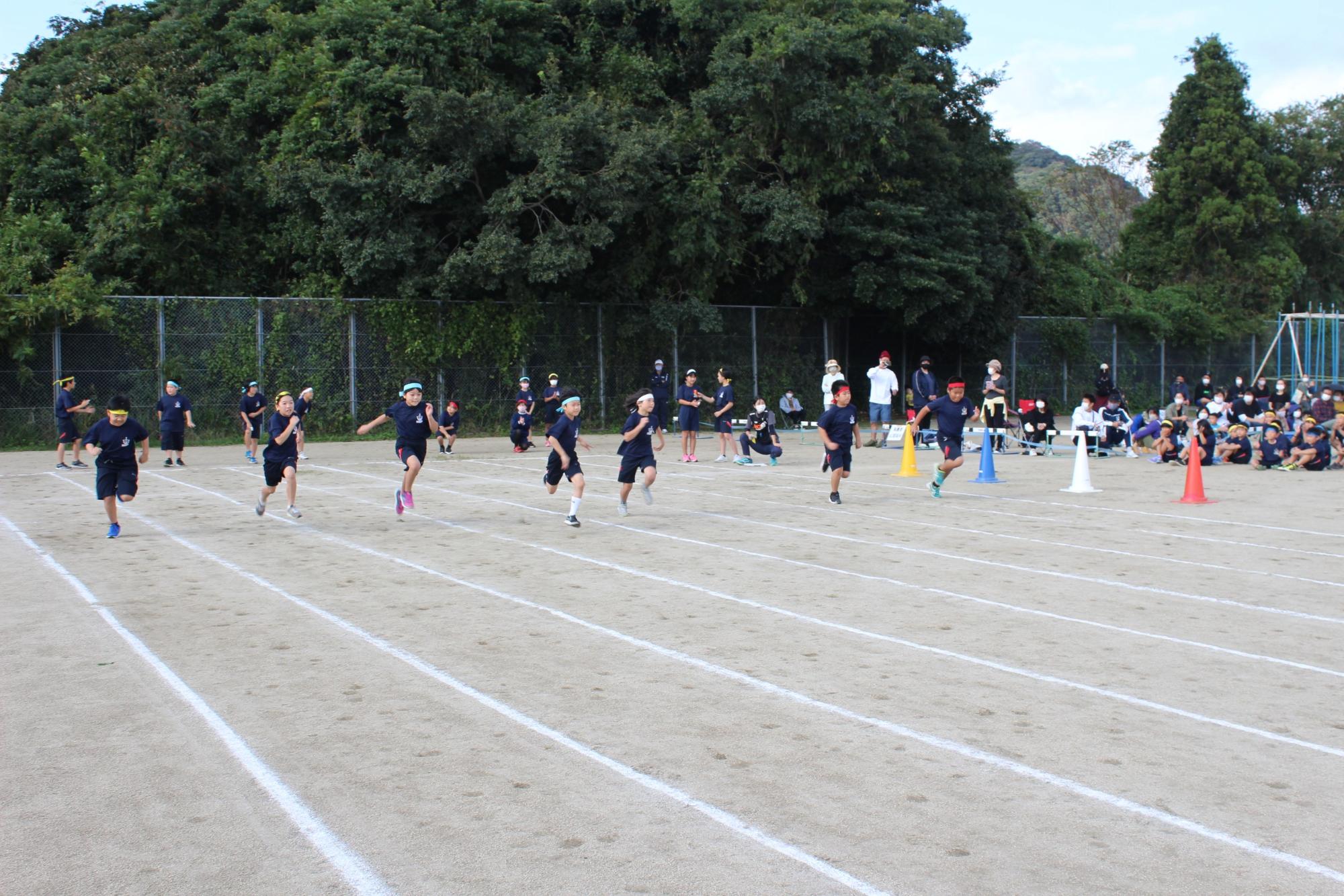 校庭で徒競走で子どもたちがゴールを目指して走る写真