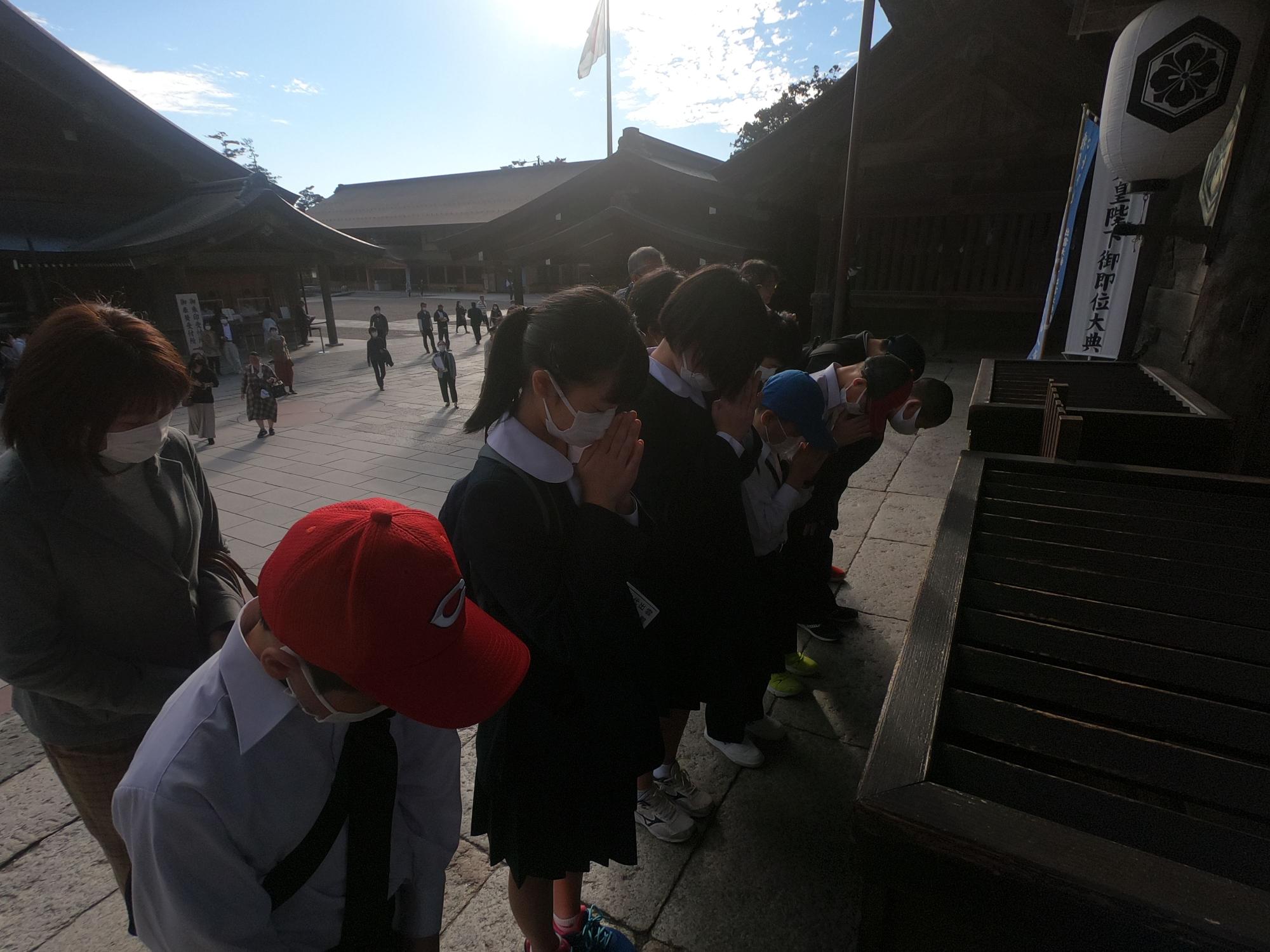 両手を合わせ、真剣な表情で横一列に並んでお祈りをしている児童たちの写真