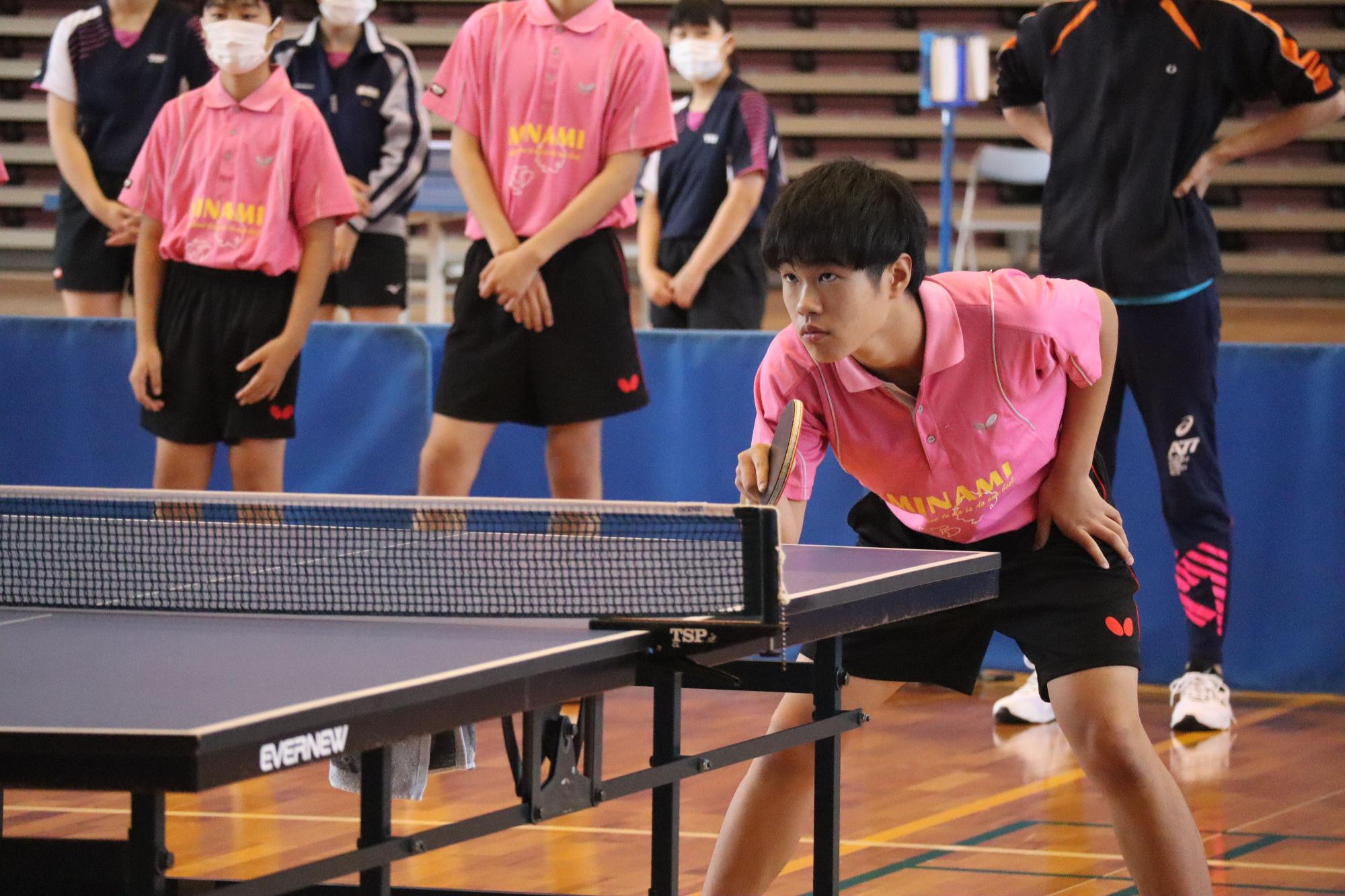 卓球の試合で真剣な表情でラケットを構える生徒の写真