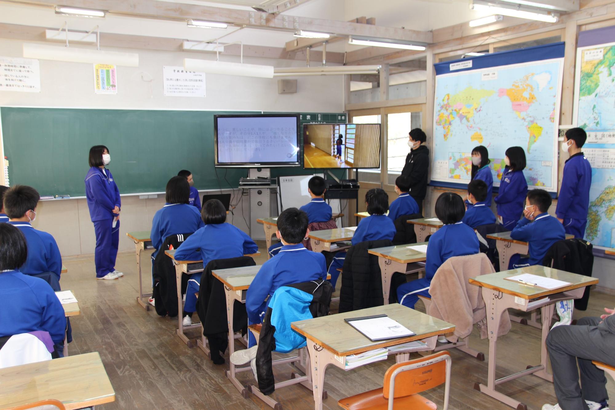 教室で生徒が前に立ち、発表を行っている写真