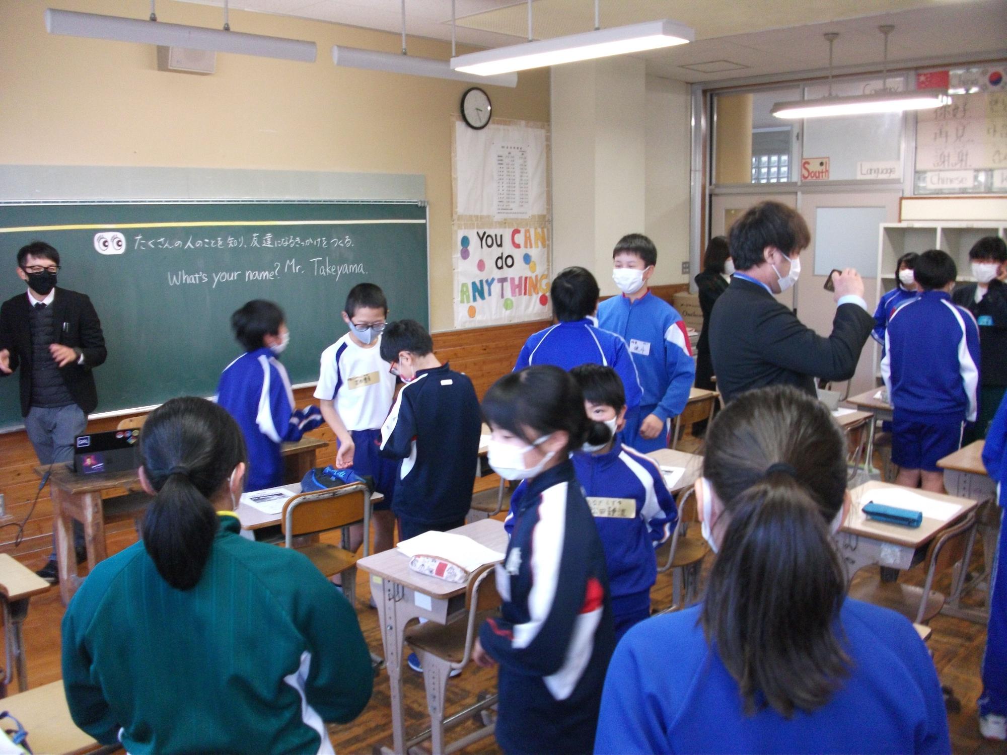 ジャージ姿の生徒たちが2人一組のペアになり、英語の授業を受けている様子の写真