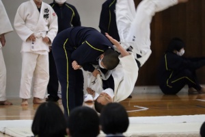 柔道場で生徒が技をかけている実技指導の写真