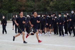 校庭で生徒たちが短距離走を競っている写真