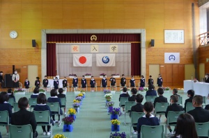 体育館で新入生が並び、入学式が行われている写真