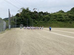 校庭で児童たちがスタート位置で待機している写真