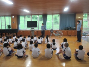 教室内で警察官が児童に自転車の安全指導をしている写真