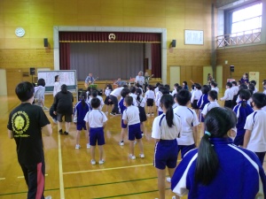 体育館で全校児童が集まり、体を動かしている様子の写真