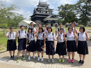 城跡公園で制服姿の生徒たちが並んで記念撮影をしている写真