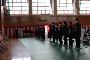 体育館で新入生と教職員が入学式に臨んでいる写真