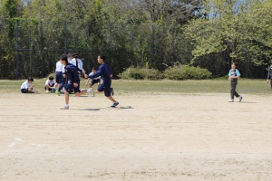 校庭で生徒たちがリレーのバトンをつないで走っている写真