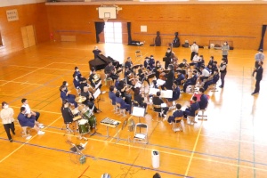 体育館で吹奏楽の演奏を楽しむ生徒たちの写真